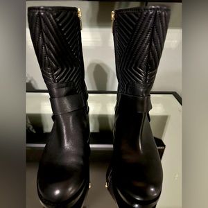Vince Camuto leather polished boot with round toe, accented with gold hardware.